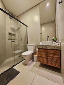 a bathroom with a toilet and a sink and a shower at Residencial Mirante in Itacaré +243 photos