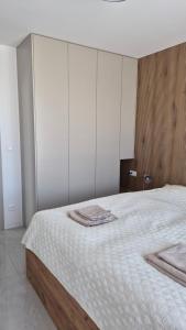 a bedroom with a large bed with white cabinets at Apartman Bartimej 2 in Bobrów