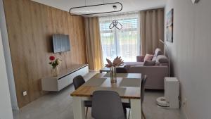 a living room with a table and a couch at Apartman Bartimej 2 in Bobrów