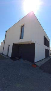a large white building with a large garage at Apartman Bartimej 2 in Bobrów