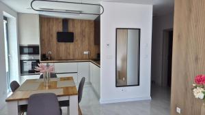 a kitchen and dining room with a table and chairs at Apartman Bartimej 2 in Bobrów