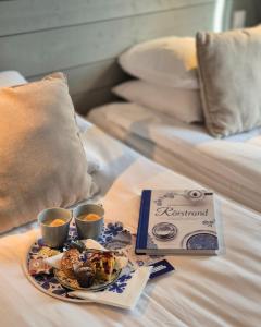 a tray of food and two cups of coffee on a bed at Hotell Rådhuset in Lidköping
