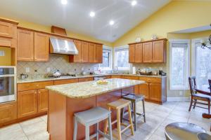 a kitchen with wooden cabinets and a island with bar stools at Spacious Lakefront in Fayetteville