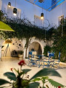 a patio with chairs and tables and ivy at Maison Lella Kmar Sidi Bou said in Sidi Bou Saïd