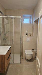 a bathroom with a shower and a toilet and a sink at Apartment Adriatica City in Makarska +20 photos