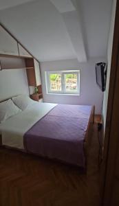 a bedroom with a large bed and a television at Žana in Kotor