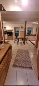 a large kitchen with a table and a tiled floor at Gemütliche Ferienwohnung am Randes des Wendlands in Schnega