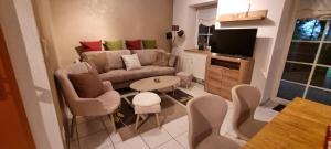a living room with a couch and a table and chairs at Gemütliche Ferienwohnung am Randes des Wendlands in Schnega