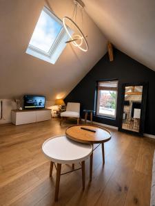 a living room with a table and a skylight at Le nid de Bertille in Le Vaudreuil