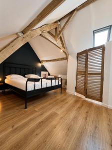 a bedroom with a bed and a wooden floor at Le nid de Bertille in Le Vaudreuil