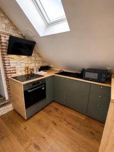 a kitchen with a stove and a sink and a window at Le nid de Bertille in Le Vaudreuil