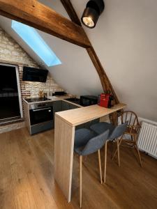 a kitchen with a wooden table and two chairs at Le nid de Bertille in Le Vaudreuil