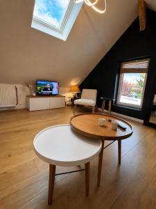 a living room with a table and a tv at Le nid de Bertille in Le Vaudreuil +4 photos