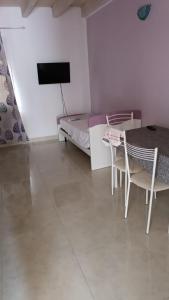 a room with a table and a bed and a television at Appartamento Masha Como in Mozzate
