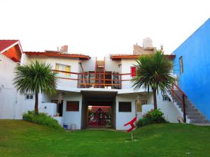 a house with two palm trees in front of it at Apartamentos Piolón-Piolón in Santa Clara del Mar