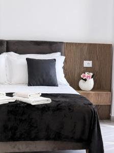 a bedroom with a bed with two white towels on it at The Honeycomb Boutique Hotel in Golem
