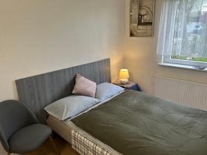 a bedroom with a bed with a chair and a window at FBC Roms Business in Rødby