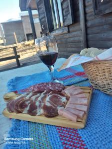 a plate of meat and a glass of wine at Cabaña Terra Nostra in Potrerillos