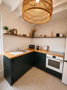 a kitchen with a sink and a large chandelier at La Petite Luce in Le Vaudreuil