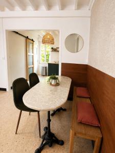 a table and chairs in a living room with a table and a chair at La Petite Luce in Le Vaudreuil