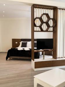 a bedroom with a bed and a tv on a shelf at The Honeycomb Boutique Hotel in Golem