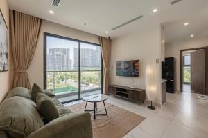 a living room with a couch and a large window at Lucent Home in Gò Công