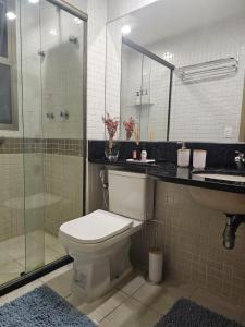 a bathroom with a toilet and a shower and a sink at Flat na praia da Barra 2 in Rio de Janeiro +6 photos