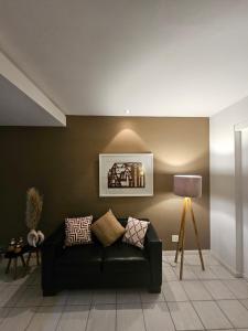 a living room with a black couch and a lamp at Flat na praia da Barra 2 in Rio de Janeiro