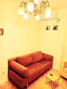 a living room with a brown couch and a table at Cozy Central Nest Kotor in Kotor