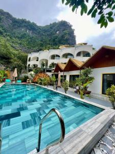 a pool at a hotel with mountains in the background at Tam Coc Harmony Homestay in Vũ Lâm