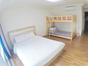 a small bedroom with a bed and bunk beds at popcorn hostel haeundae in Ch'ŏngsap'o