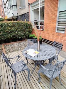 a table and chairs on a wooden deck at Prisma Suites Chico 94 in Bogotá