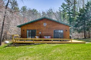 a log cabin with a large deck in the grass at Long Lake Cabin w/ Dock: Fish & Hike! in Walker