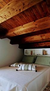 a bed in a room with a wooden ceiling at Ca' Libellula Casa Vacanza in Avola