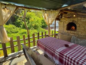 a patio with a table and a stone fireplace at ART Guest Home in Leshten
