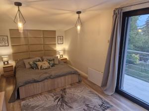 a bedroom with a bed and a large window at Paradise Vibe Balaton in Balatonkenese +18 photos