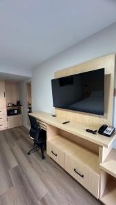 an office with a desk with a television and a chair at Super 5 Inn in Mississauga