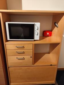 a microwave sitting on top of a wooden cabinet at Sun life room in Stockholm