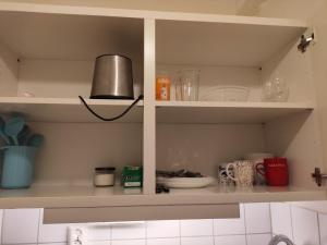 a kitchen shelf with dishes and a lamp on it at Sun life room in Stockholm +1 photo