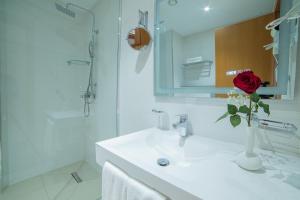 Ein Badezimmer mit einer roten Rose in einer Vase auf dem Waschbecken in der Unterkunft Barkat hôtel in Baraki + 41 Fotos