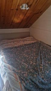 a bed in a room with a wooden ceiling at Chalet à la campagne 40m2 in Charleval