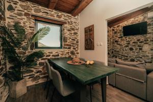 a dining room with a green table and a couch at Ellafos Traditional Living-Elafonisi Couples Retreat in Elafonisi