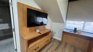 a living room with a television on a wooden dresser at Super 5 Inn in Mississauga