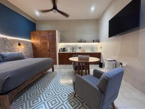 ein Schlafzimmer mit Bett und Tisch und eine Küche in der Unterkunft Casa Tunkul in Mérida