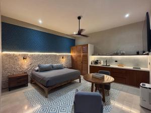 ein Schlafzimmer mit Bett und Tisch und eine Küche in der Unterkunft Casa Tunkul in Mérida