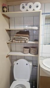 a bathroom with a toilet and towels and a sink at Chalet à la campagne 40m2 in Charleval