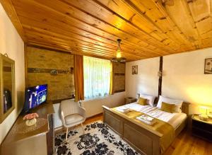 a bedroom with a bed and a tv in a room at ART Guest Home in Leshten
