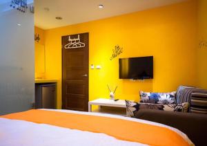 a bedroom with a bed and a tv and a couch at 羅東簡單住一晚 in Luodong
