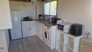 a kitchen with a refrigerator and a microwave and a stove at Chalet à la campagne 40m2 in Charleval +2 photos