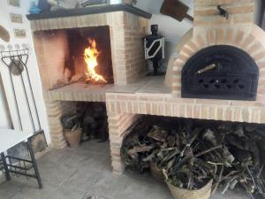 a brick fireplace with a fire in it at Casa Rural Eufemia in Arenales de San Gregorio